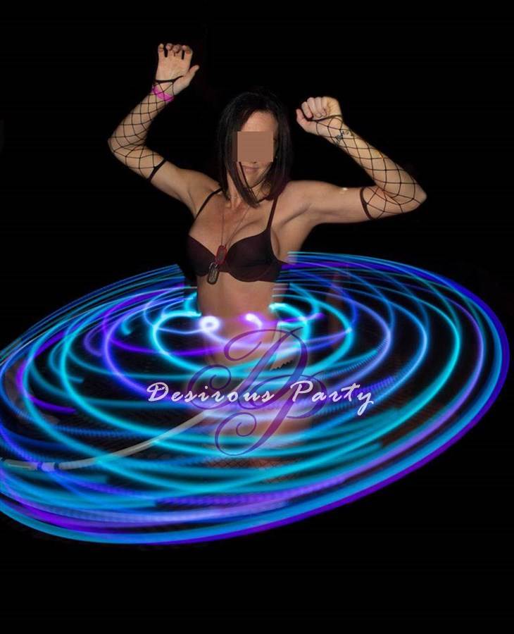 A sexy female party guests spinning the glowing hoola hoop in houston at purgatory heaven or hell weekend. 